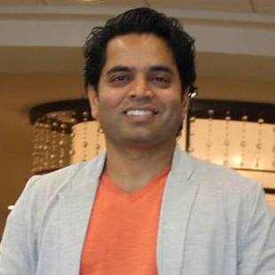 Portrait of man with gray blazer and orange shirt